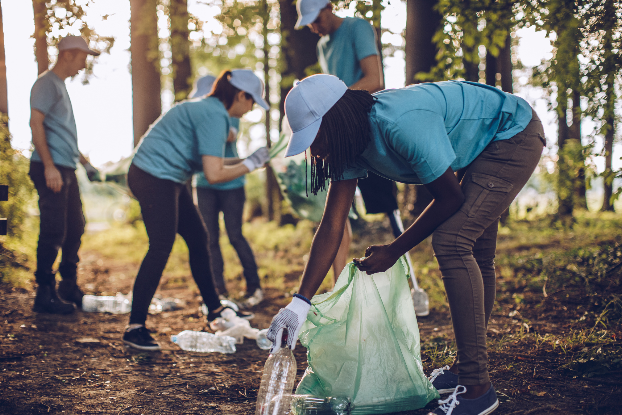 Group of community volunteers cleaning up trash in public park